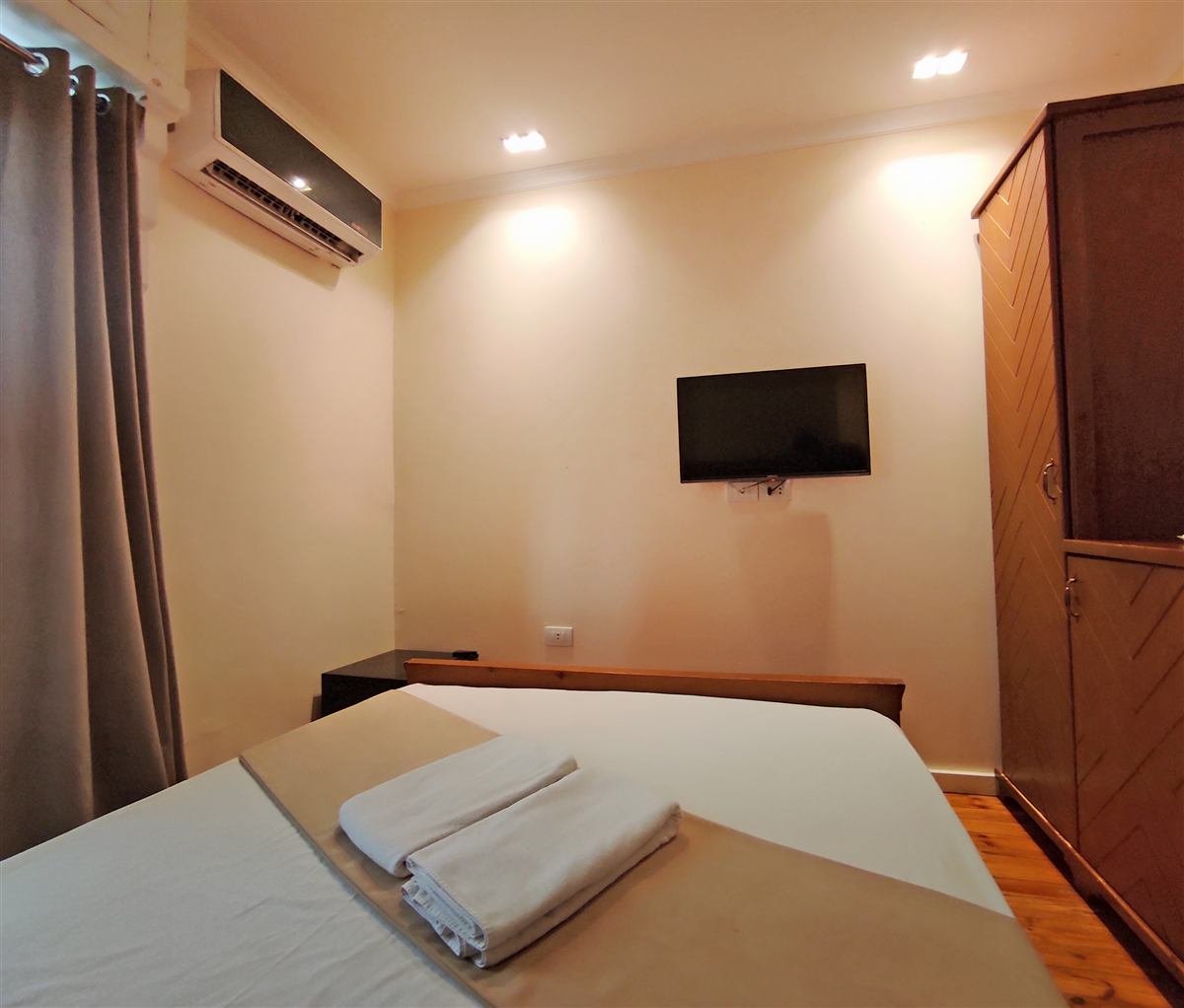 Double room with a wooden bed, wall TV and air conditioning