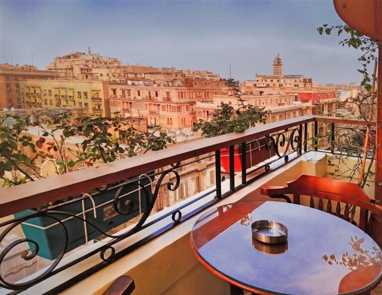 Balcony with a round table and chairs over the Downtown Cairo rooftops